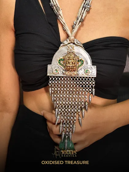 This is a piece of heritage reimagined. My oxidized silver treasure necklace features a temple motif and intricate silver meshwork, designed for the woman who is bold, confident, and carries her story with grace.