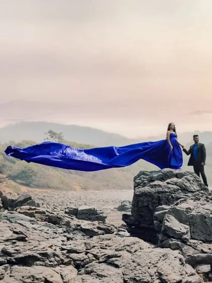 The royal blue gown stands out against the rugged, rocky landscape. This is a perfect choice for couples who want a bold color for their adventure pre-wedding session.