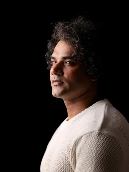 A moody, low-key portrait of actor Alok Singh against a black backdrop. This style of lighting sculpts the face and creates a sense of introspection and intensity.