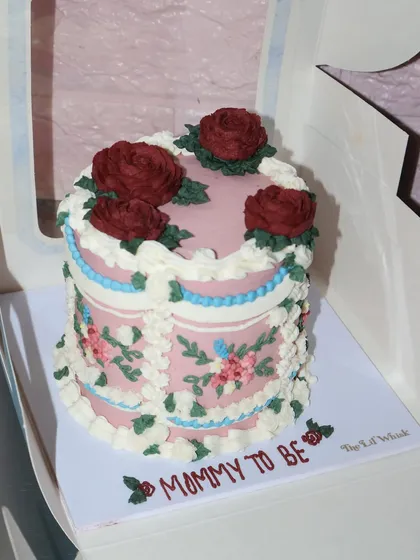 Vintage florals and soft hues for a special "Mommy to be." This cake combines delicate piped flowers with classic frills and deep red buttercream roses.