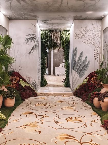 The entrance corridor to the 'Orchard of Life' naming ceremony, lined with earthen pots and floral arrangements.