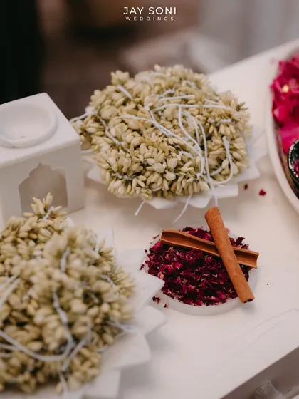 Traditional offerings of jasmine gajras and spices like cinnamon, beautifully arranged as part of the decor.