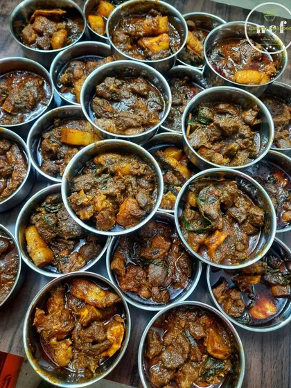 Individual portions of my buff and pork curry, ready to be packed for a tiffin service or event.
