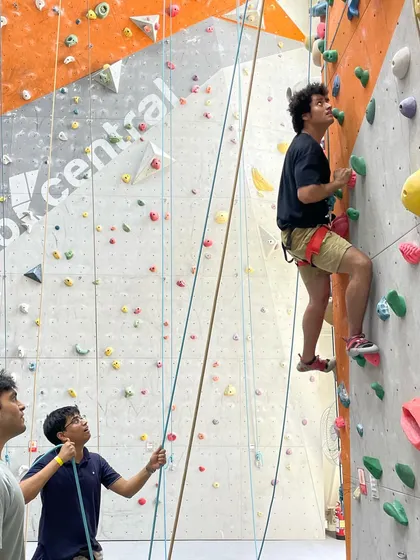 A belayer keeps a watchful eye on his climber, ensuring safety while offering support.