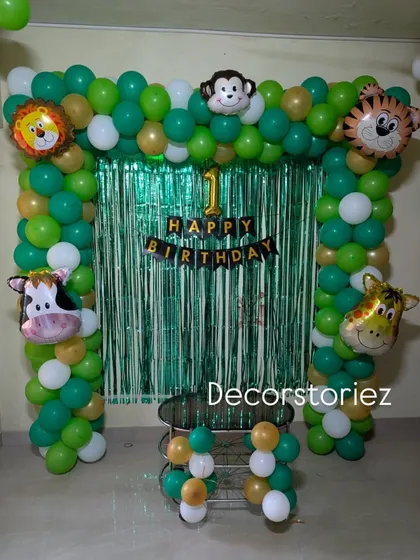A clear, centered shot of the jungle theme balloon arch, perfect for a cake-cutting ceremony at home.