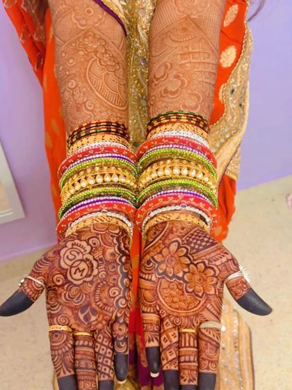 The bride's hands adorned with colorful bangles that make her deep henna stain stand out even more. A perfect combination for any wedding function.