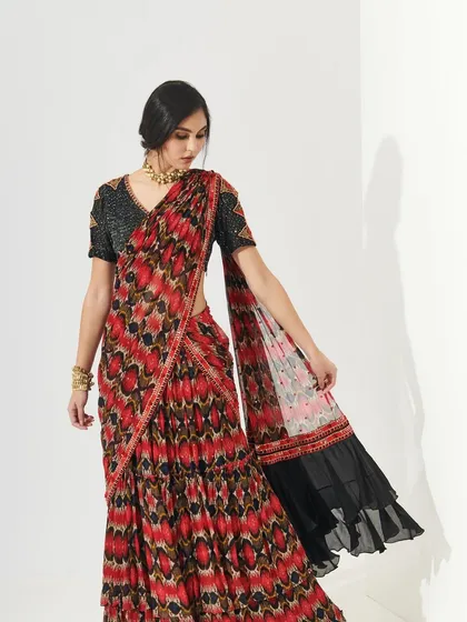 A stunning printed saree with a modern silhouette. The makeup is elegant and refined, with a classic winged liner and a flawless base that complements the intricate patterns of the outfit.