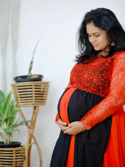 I love capturing these quiet, beautiful moments. This comfortable red and black maternity gown features delicate embroidery on the sleeves, adding a touch of elegance to your special photoshoot.