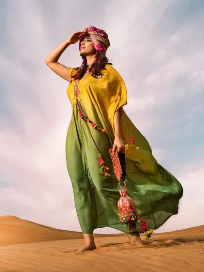 A shot from our "habibi vibes" series, featuring a vibrant, flowing kaftan and a traditional head wrap. The styling and pose evoke a sense of looking towards the horizon, full of hope and adventure.