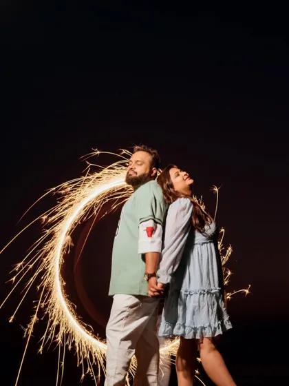 A creative long-exposure shot using a sparkler to draw a circle of light around the couple. This technique, known as light painting, adds a unique and magical touch to night-time pre-wedding shoots.