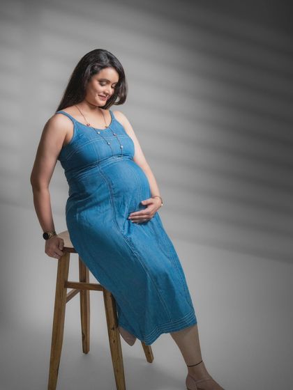 Capturing the essence of motherhood is always a special moment. This serene shot in a simple denim dress showcases the calm anticipation of welcoming a little one.