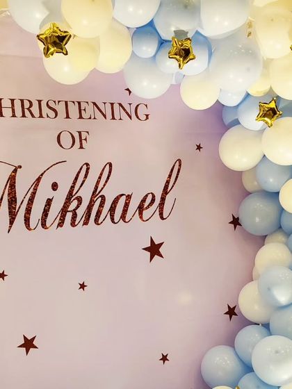 A close-up of the custom backdrop for Mikhael's Christening, showing the "Christening of Mikhael" text and star details.