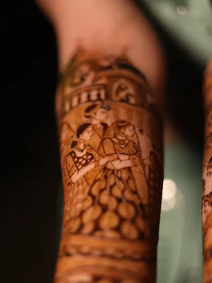 A close-up of a family portrait within a bridal mehandi. Including loved ones in the design makes it even more special.