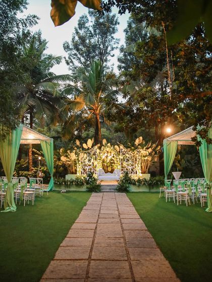 A collection of stunning wedding setups at The Farmhouse Collective. You can see the venue's versatility, from elegant morning ceremonies with floral mandaps to glamorous evening receptions with fairy lights and chic decor. This space is a blank canvas for your dream outdoor wedding in Bengaluru.