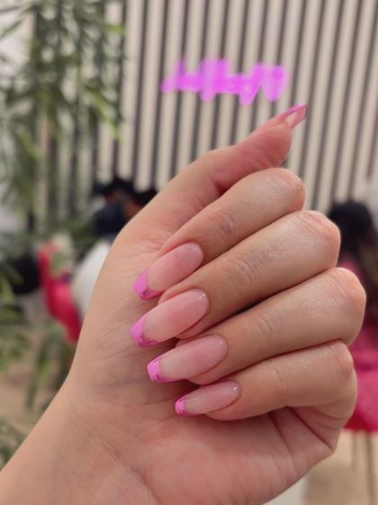 A fun and trendy look featuring hot pink chrome French tips on long oval extensions.