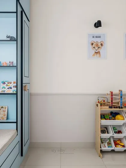 A well-organized play and storage area in the kid's room. The open toy shelf and personalized wall art make the space feel personal, tidy, and ready for fun.