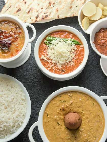 A classic North Indian meal spread. This image features some of our staples like Dal Tadka, Paneer Butter Masala, and Gatte ki Sabzi, served with steamed rice and naan.