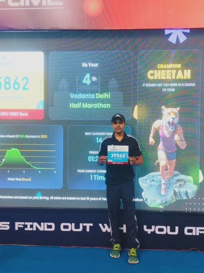 Standing proud with my race bib after completing the Vedanta Delhi Half Marathon.