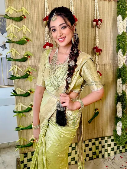 The client playing with her long, decorated braid, looking joyful and radiant.