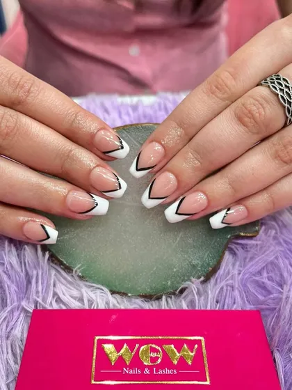 This edgy, graphic French manicure features a V-shaped tip with a sharp black outline. It's a bold and modern twist on a classic style.