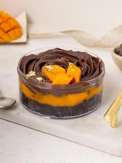 A chocolate and mango tub dessert, a classic combination. The styling highlights the swirls of dark chocolate mousse and the bright pop of fresh mango.