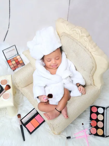 A playful spa day theme for this little one. Dressed in a tiny bathrobe with makeup palettes nearby, this sleeping baby is enjoying a day of pampering.