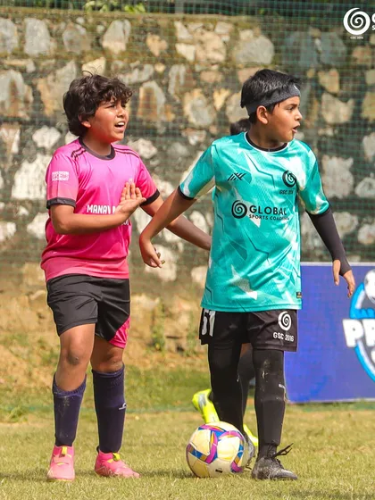 Two young players, one from GSC and one from Manav Rachna, challenge for the ball.