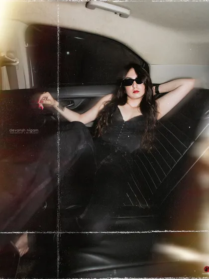 A wide shot capturing the full vintage vibe of the car's interior and the outfit.