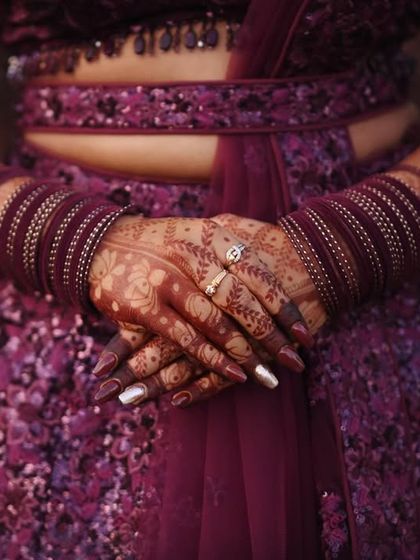 The deep color of the stain looks gorgeous with the bride's purple outfit and bangles.