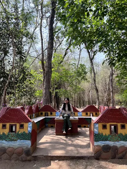 Sitting in a whimsical, village-themed installation within the park. I love discovering artistic and playful elements in unexpected places.