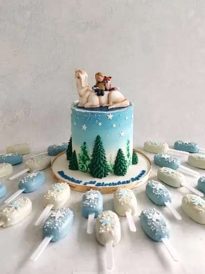 A heartwarming cake inspired by the book "The Boy, the Mole, the Fox and the Horse," complete with a wintery scene and matching cakesicles.