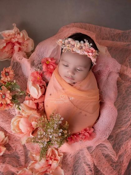 A cocoon of peach-colored lace and flowers. The monochromatic color scheme is soft, elegant, and timeless, creating a truly artistic portrait.