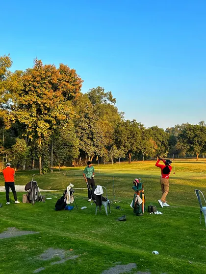 A group of friends enjoying a weekend session on the grass tees, with the trees showing their autumn colors.