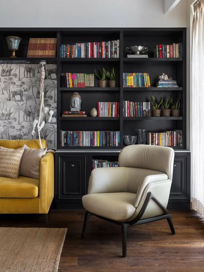 This cozy corner of the Magnolia project is rich with character. The dramatic backdrop of dark, built-in bookshelves creates a sense of history, while a playful wallpaper adds a touch of the unexpected. The elegant, sculptural armchair from my Koko collection is a beacon of comfort and high design.