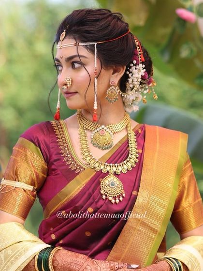A profile view showing the elegant hairstyle and the intricate details of the bridal jewelry. The makeup is blended seamlessly for a perfect side profile.