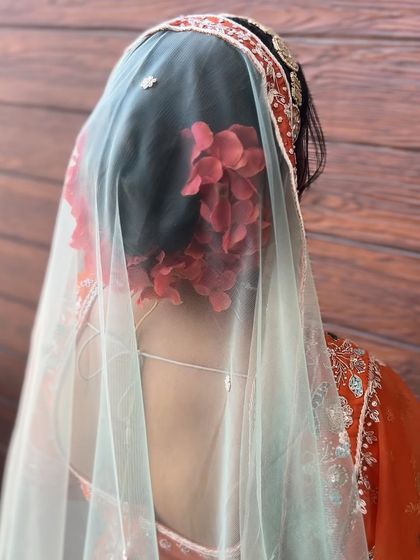 The same red floral bun, seen through a delicate veil, creating a soft and romantic effect.