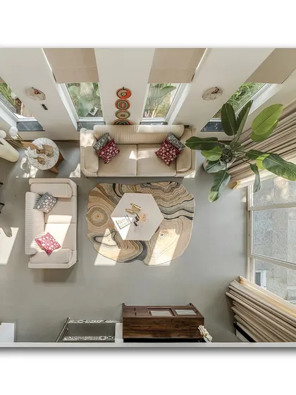 An overhead shot of the living room, revealing the thoughtful layout and the beautiful patterns of the rug. This perspective highlights the interplay of shapes, from the hexagonal coffee table to the arrangement of the sofas.