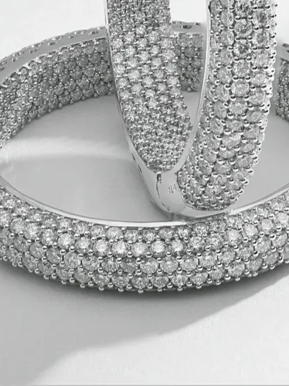 This macro photograph captures the intricate detail of pavé-set diamond hoop earrings. Every single diamond is in sharp focus, demonstrating the precision required for high-end e-commerce imagery where texture and quality are paramount.
