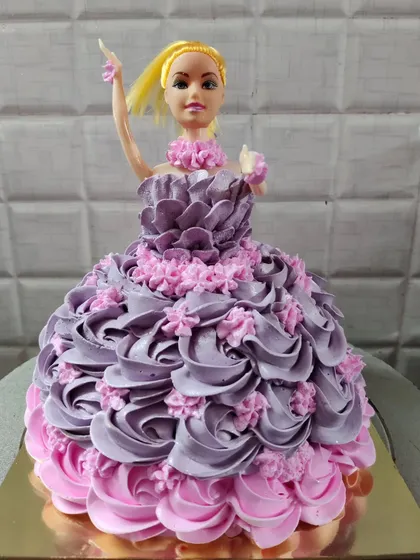 My classic doll cake, a favorite for children's birthdays. This design features a beautiful gown made of intricately piped purple and pink buttercream rosettes.