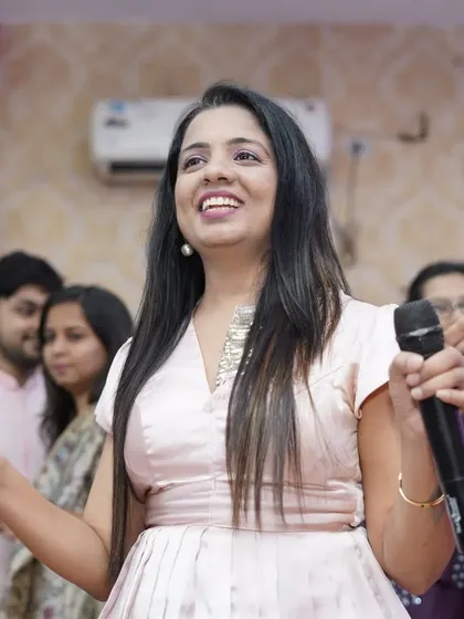 A close-up shot of me in action, mic in hand, at a baby shower. I am passionate about my work and love bringing energy and excitement to every celebration.