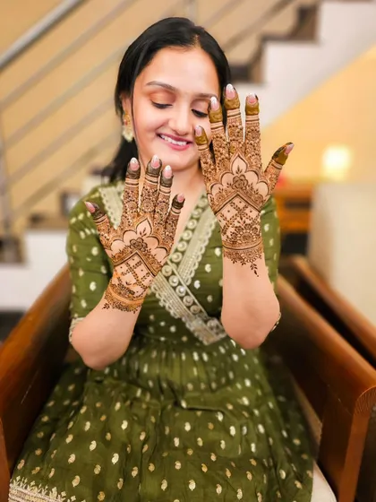A happy bride showcasing her lovely minimal henna, perfect for her engagement or sangeet.