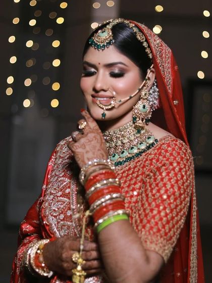 A dreamy shot with a beautiful bokeh background. The focus is on the bride's happy expression and her flawless makeup, featuring smokey eyes and a perfectly defined lip.
