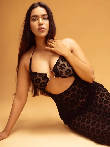 A striking pose in a black floral cutout dress. The direct gaze and composition make this a strong image for a campaign or social media feature.