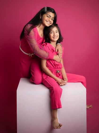 A sweet and gentle moment between two sisters. The older sister's embrace is so loving, creating a beautiful portrait of sisterhood.