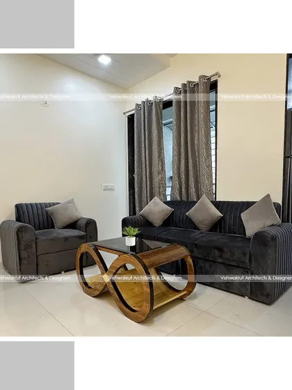 The living room setup for a 1BHK apartment, featuring a comfortable sofa set and a unique infinity-style center table. This shows how we select furniture that is both functional and a piece of art in itself.