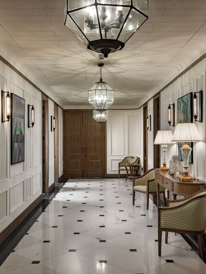 The main corridor of the VRS Office is designed with classical elegance. Fluted wall mouldings, checkerboard marble flooring, and ornate pendant lights create a grand and timeless passageway that feels more like a luxury hotel than a corporate office.