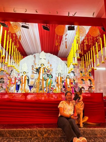 A serene moment captured as a pet parent sits with her German Shepherd at the base of the pandal. Our events provide a calm and safe space for all breeds to participate.