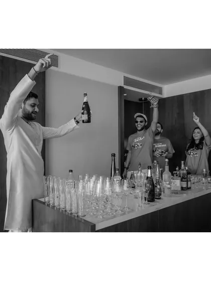 The groom, Shivam, kickstarts his own baraat in his suite with his friends. This black and white shot captures the energy and anticipation before the official procession even begins.