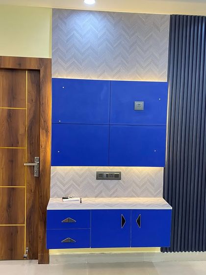 A bold and vibrant TV cabinet in royal blue and white, set against a wall with fluted and textured panels.