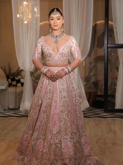 A close-up of the modern pink bridal lehenga. The plunging neckline and the intricate embroidery make it a bold and beautiful choice.